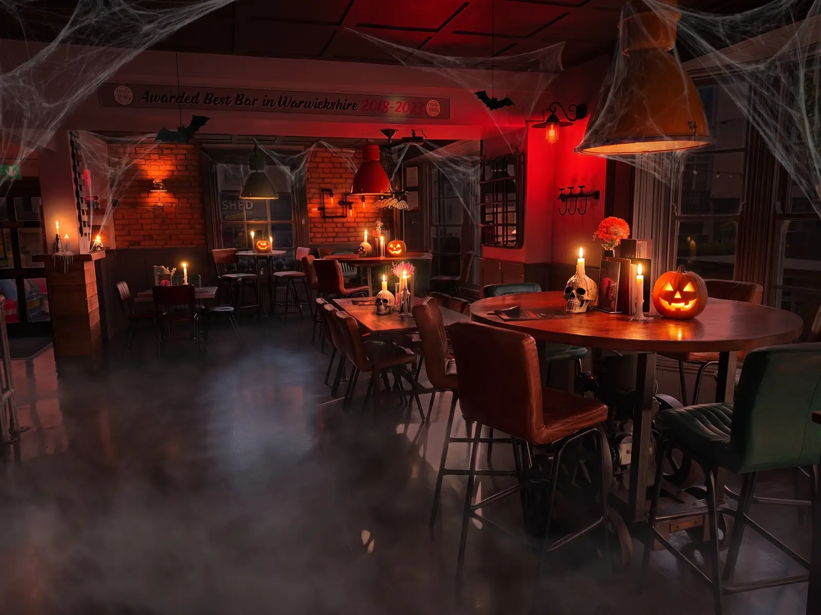 Fizzy Moon dining room dressed for Halloween with cobwebs, candles and pumpkins